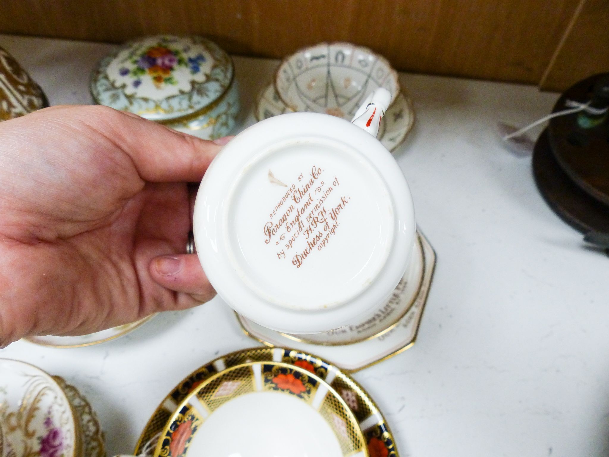 A group of Dresden and Continental porcelain cups and saucers boxes and covers and a scent bottle, 14 cm high